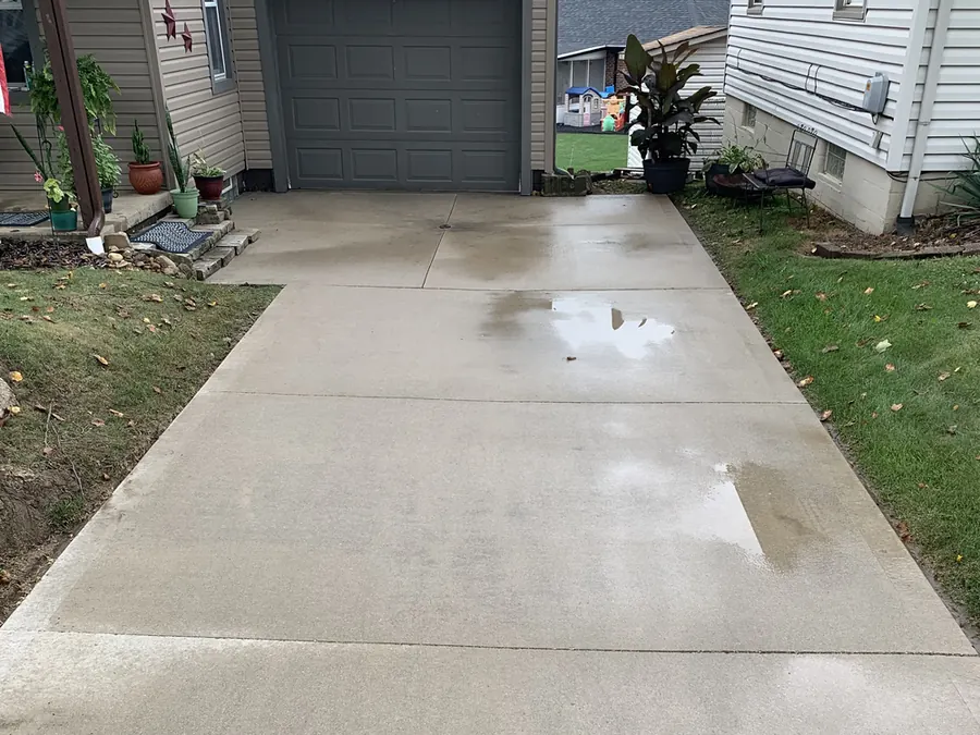 The same driveway after cleaning by Bronny's Power Washing, back to an even light concrete finish.