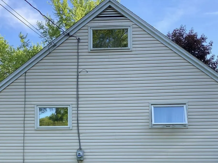 The same vinyl siding after soft washing by Bronny's Power Washing, with the algae and staining removed and the original light colour restored.